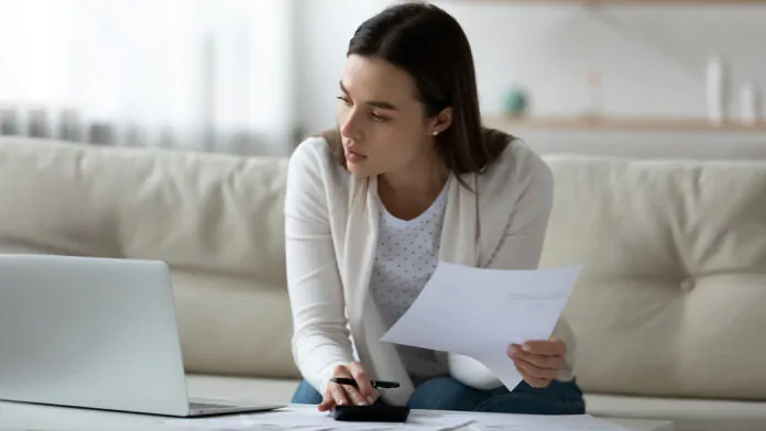 ragazza prende appunti davanti al pc per l'assegno di inclusione