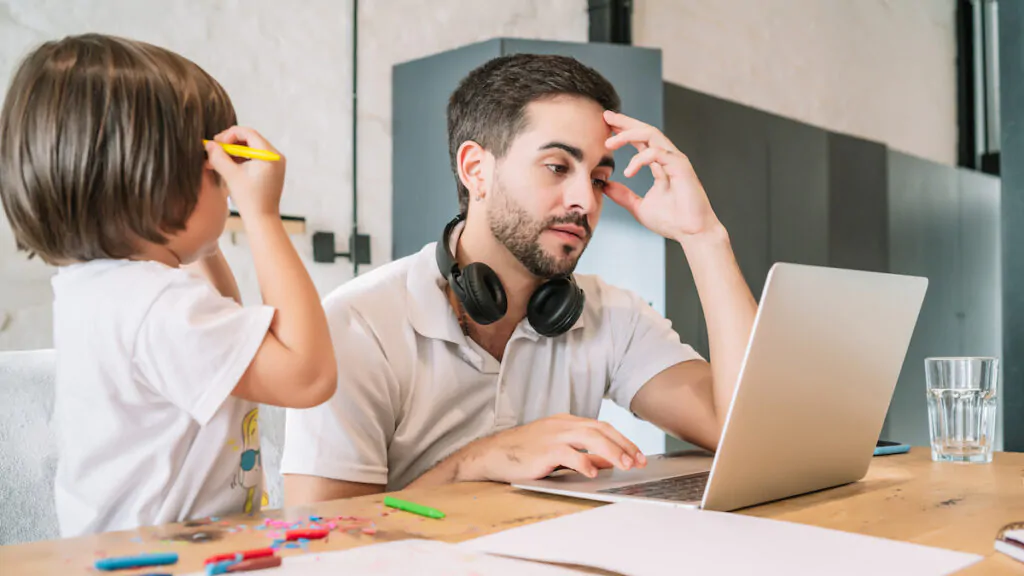 smart working, padre lavora da casa con suo figlio