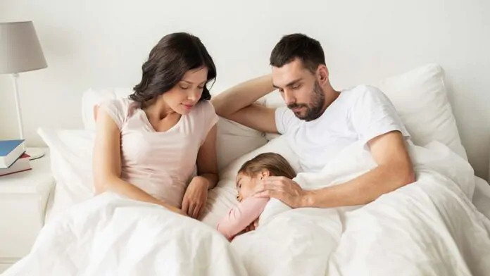 assegno unico per i figli, famiglia dorme nel letto matrimoniale