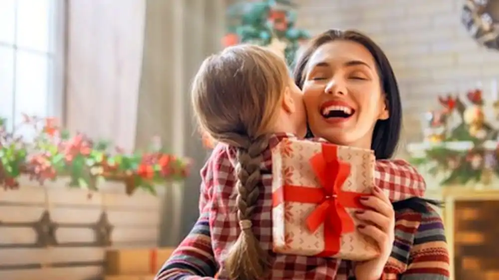 mamma scarta regalo di natale con figlia